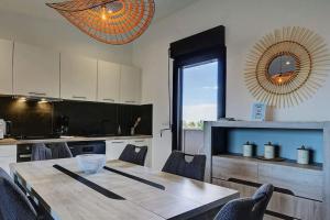 eine Küche mit einem Tisch, Stühlen und einem großen Spiegel in der Unterkunft Leu Burgot 2, Appartement 17 in Saint-Leu