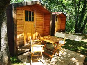 una mesa de picnic y sillas frente a una cabaña en Krasen Kras 104 resort, en Komen