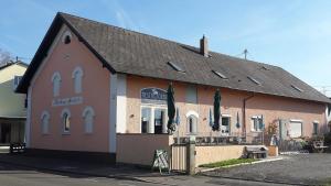 um edifício com um restaurante com guarda-sóis em frente em "Nesthocker" Café-Snackbar-Pension-Bauwagencamp em Offingen