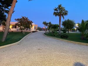 uma entrada que leva a uma casa com palmeiras em B&B Villa Jonica em Gallipoli
