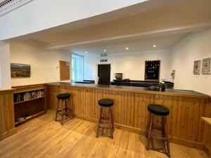 a bar in a room with two stools at a counter at Mackay's Spa Lodge Hotel in Strathpeffer