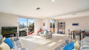 a living room with a couch and a tv at Sanctuary #12 Accom Holidays in Terrigal