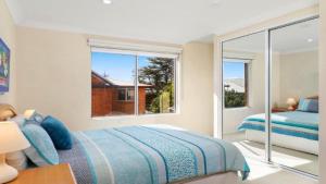 a bedroom with a bed and a large window at Sanctuary #12 Accom Holidays in Terrigal