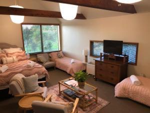 a living room with two beds and a flat screen tv at Summerfields B & B in Cambridge