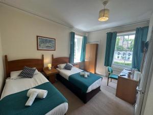 a hotel room with two beds and a window at Mackay's Spa Lodge Hotel in Strathpeffer