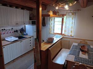 a kitchen with a refrigerator and a table in it at Chata Smrek a kontaktná MINI ZOO in Jezersko