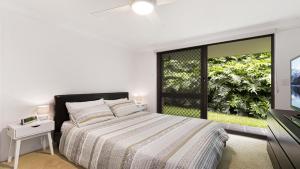 a white bedroom with a bed and a window at Terrigal Bay #19 Pool , Short Walk To Beach Accom Holidays in Terrigal
