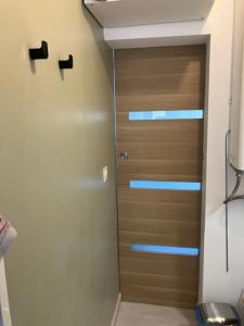 une salle de bain avec une porte en bois dans une pièce dans l'établissement Appartement Cosy à 300m de la Mer / Cosy flat at 300m from the sea, à Merlimont