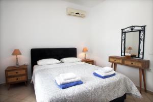 a bedroom with a bed with two towels on it at Echinades Resort in Vasiliki