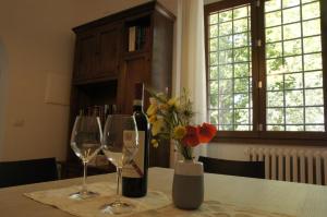 佛羅倫斯的住宿－Il Sottolo，一张桌子,上面放着两杯酒,花瓶上放着鲜花
