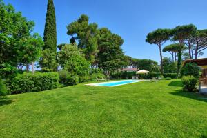um quintal com piscina e árvores em Villa Dolce Vita by PosarelliVillas em Punta Ala
