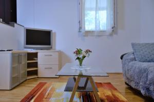 - un salon avec une télévision et une table fleurie dans l'établissement Apartments Meli, à Zadar