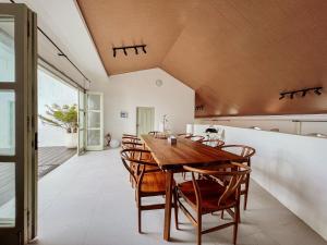 a dining room with a wooden table and chairs at Renjana Beach House in Bira