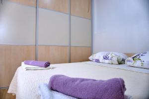 - un lit avec 2 oreillers et des serviettes pourpres dans l'établissement Apartments Meli, à Zadar