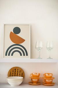a shelf with plates and glasses and a picture at The Springfield Corner Apartments by Konnect in Ipsos