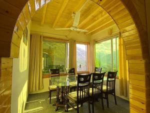 a dining room with a table and chairs and a window at Hunza Lounge in Hunza Valley