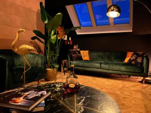 een woonkamer met een groene bank en een tafel bij LoCo Paradiso - Two kingsize beds, outdoor terrace, DJ booth, bar, cinema, bathtub, kitchen, airco in Antwerpen