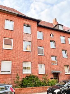 a red brick building with a dog in the window at Wohnung für 5 Gäste große Küche Messe- und Citynah in Hannover