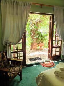 a bedroom with a door open to a patio at Springfontein Guesthouse in Springfontein