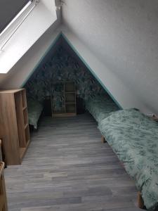 Cette chambre mansardée comprend un lit et une table. dans l'établissement Le gite du fresne la samare, à Saint-Pierre-en-Val