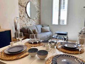 a table with plates and wine glasses on it at Au cœur du viel Antibes - Cosy appartement in Antibes