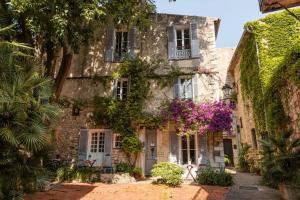 an old stone house with purple flowers in front of it at Au cœur du viel Antibes - Cosy appartement in Antibes