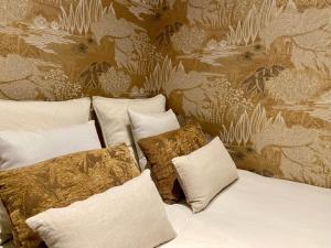 a group of pillows on a bed with a wall at Au cœur du viel Antibes - Cosy appartement in Antibes