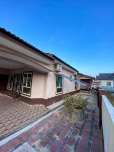 a house with a brick sidewalk in front of it at Ceiba View Homestay in Dungun