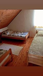 two beds in a room with wooden floors at Apartman Ivano in Gospić
