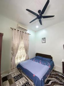 a bedroom with a bed and a ceiling fan at Ceiba View Homestay in Dungun