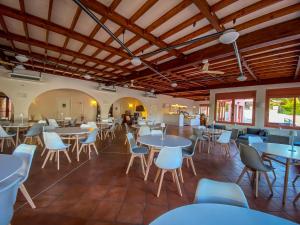 uma sala de jantar com mesas e cadeiras em La Mandola eco Hostel em Ilha Capraia
