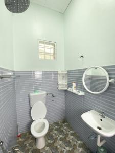 La salle de bains est pourvue de toilettes, d'un lavabo et d'un miroir. dans l'établissement Ceiba View Homestay, à Dungun