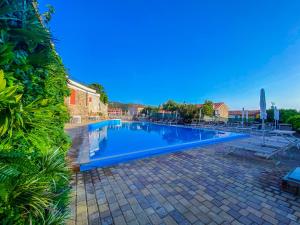 uma grande piscina azul num pátio em La Mandola eco Hostel em Ilha Capraia