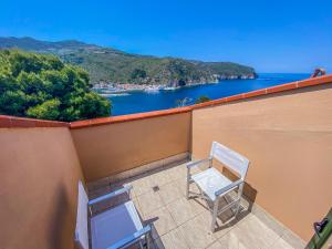 2 sedie su un balcone con vista sull'acqua di La Mandola eco Hostel a Capraia