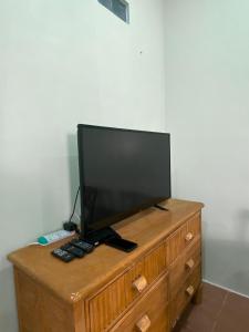 a flat screen tv sitting on top of a wooden dresser at Ceiba View Homestay in Dungun