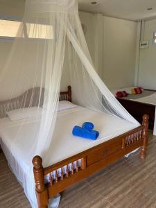 a wooden bed with a blue ribbon on it at Khao Sok Hill Top Resort in Khao Sok