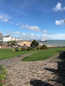 una passerella in pietra che conduce a una spiaggia con l'oceano di OYO Carlton Court Hotel a Eastbourne