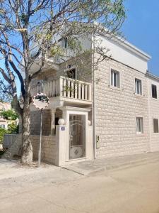 ein weißes Backsteingebäude mit einem Basketballkorb davor in der Unterkunft Apartment Villa Sunshine in Sutivan