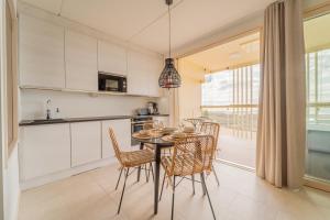 a kitchen and dining room with a table and chairs at Marina Resort Apartments by Hiekka Booking in Kalajoki