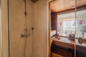 een badkamer met een douche en een glazen deur bij Marina Resort Apartments by Hiekka Booking in Kalajoki