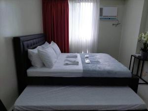 a bed in a small room with a window at ZackG Serene Homestay at Brenthill 210 Baguio in Baguio