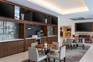 a dining room with a table and chairs and television at Hanover Marriott in Whippany