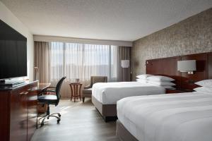 a hotel room with two beds and a television at Hanover Marriott in Whippany