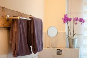 a bathroom with purple towels hanging on a towel rack at FLAIR Bad Rodach - 5 Sterne Ferienwohnungen in Bad Rodach