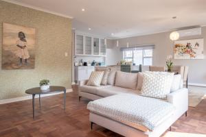 ein Wohnzimmer mit einem Sofa und einem Tisch in der Unterkunft 74 on 19th in Johannesburg