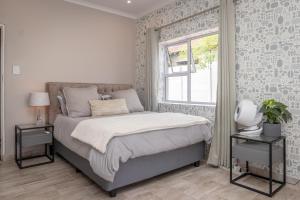sypialnia z łóżkiem z oknem i dwoma stołami w obiekcie 74 on 19th w mieście Johannesburg