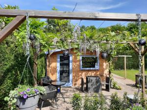 un cottage avec une pergola dans un jardin dans l'établissement B&B Paardenhof, à Wapenveld