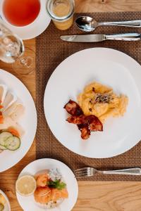 a table with white plates of food and drinks at Klosterhof – Alpine Hideaway & Spa in Bad Reichenhall