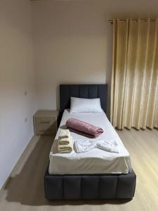 łóżko z dwoma ręcznikami w pokoju w obiekcie Jons Apartment w Gjirokastrze