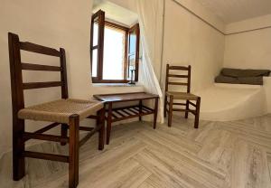 - une chambre avec deux chaises, une table et un lit dans l'établissement Amphora Guesthouse & Apartments, à Himarë